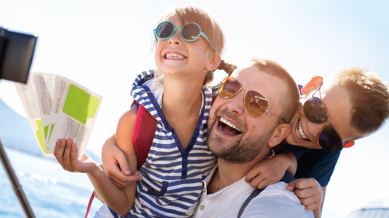 Family selfie with child holding tickets