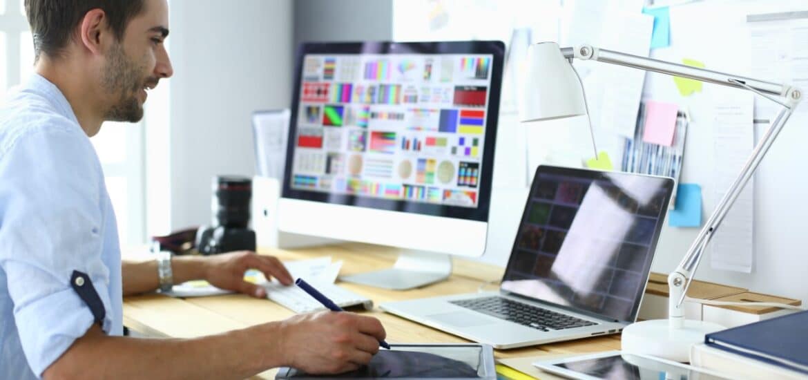 Woman sitting at computer working on graphic design assignment