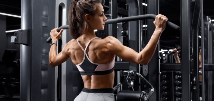 woman working out in gym lat pull down muscles