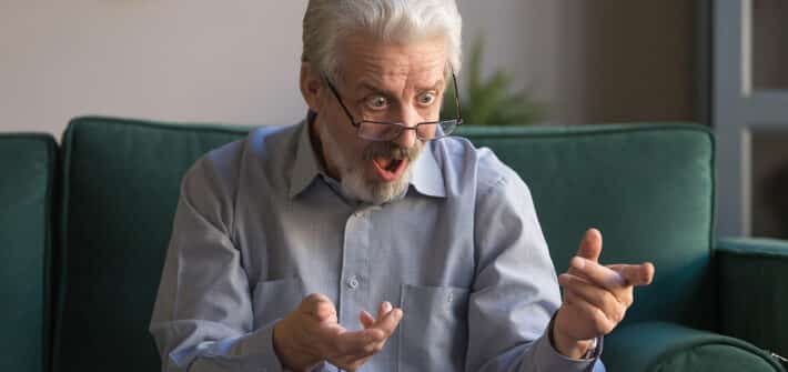 Shocked stressed senior mature man looking at laptop reading unbelievable online news at home, crazy senior old grandpa feel bad surprise with unexpected computer problem, frustrated by system virus