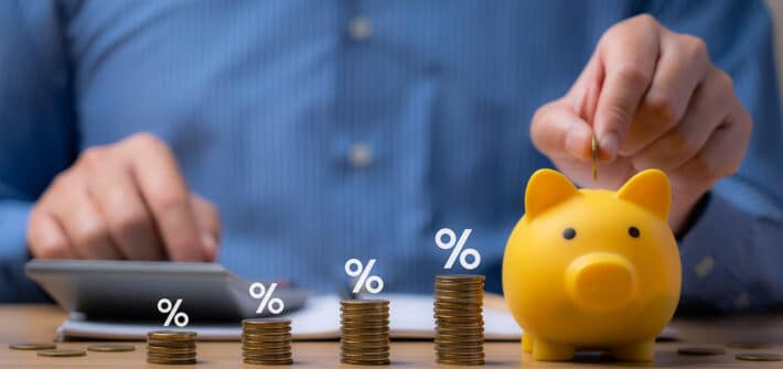 pile of coins and piggy bank, Interest rate and dividend concept Businessman is calculating income and return on investment in percentage. income, return, retirement, compensation fund, investment