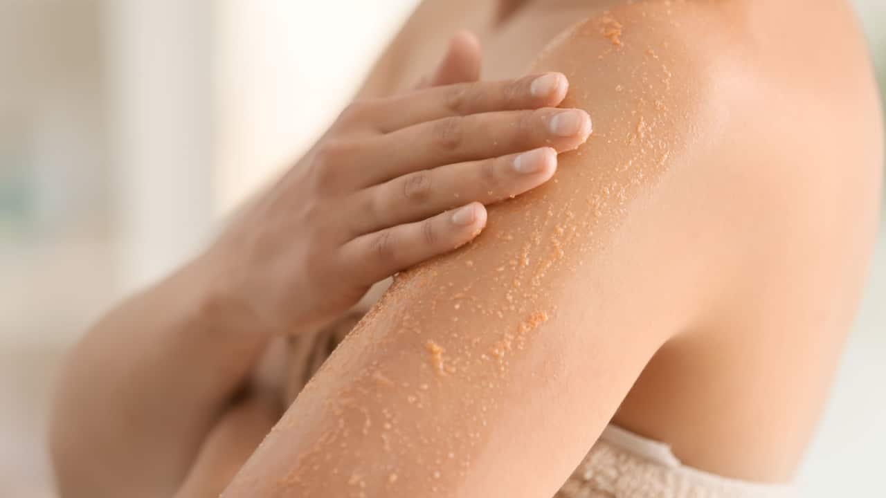 Woman applying exfoliating scrub