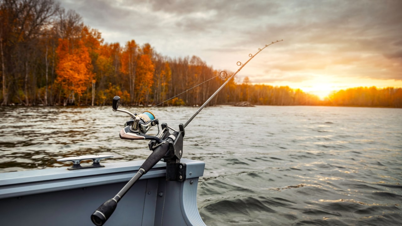 Fishing rod on the boat, sunset time. Beautiful autumn colors.