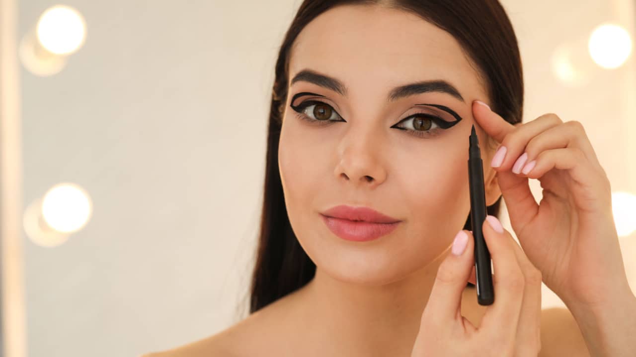 Woman applying black eyeliner