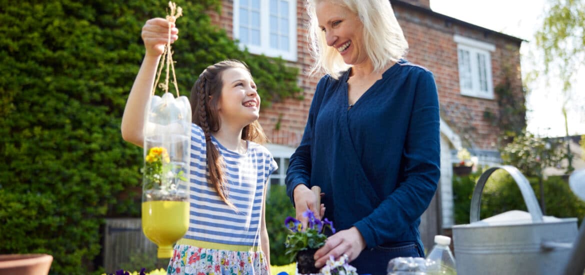 young girl and a woman repurposing household items to use in the garden