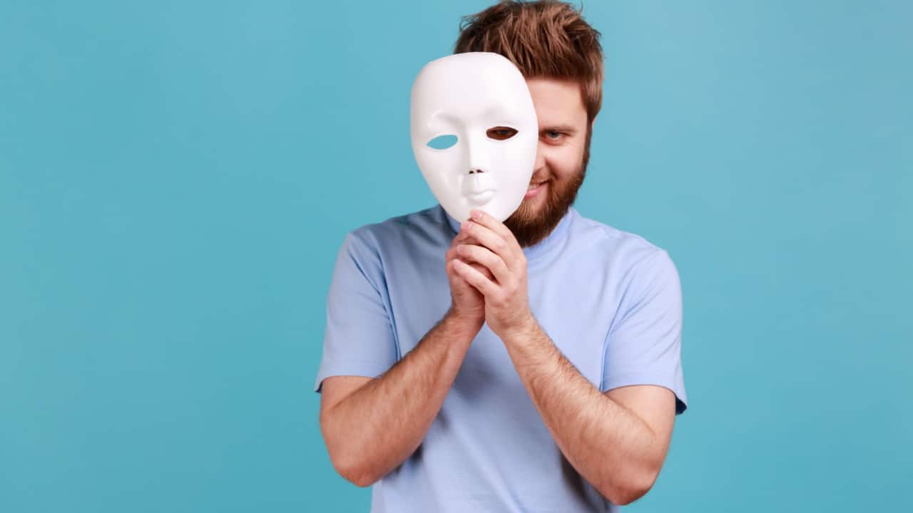 Young man wearing a white mask to stay hidden