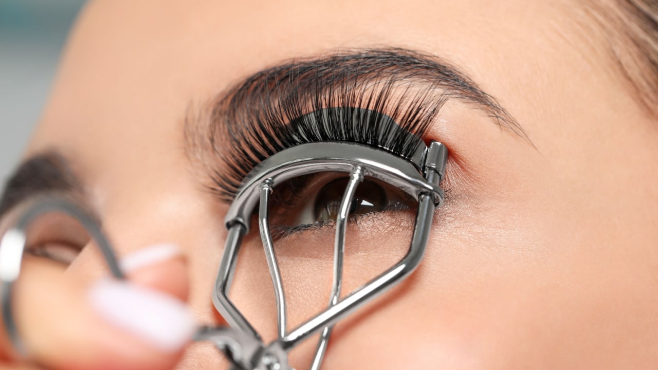 Woman using eyelash curler