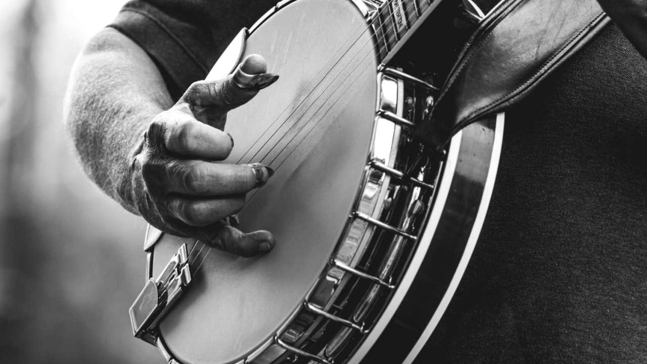 mature, older man, male playing five string banjo outside
