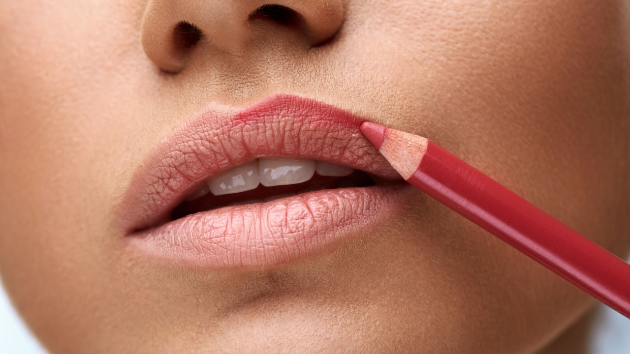 Woman applying lip liner makeup