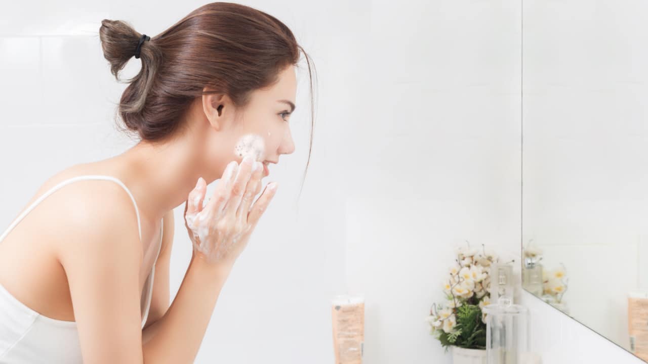 Woman cleansing face