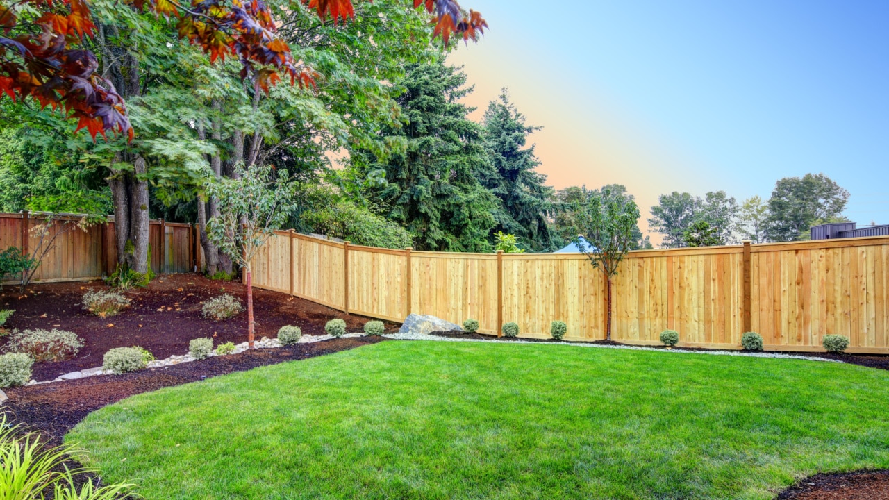 backyard with new planting beds with stained painted wooden fence