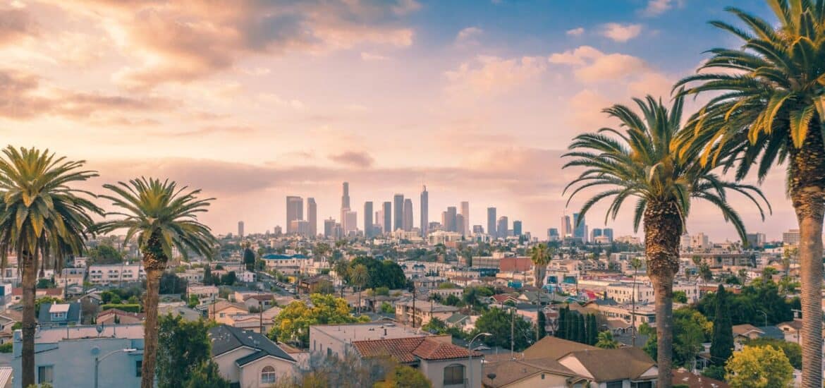 Beautiful sunset of Los Angeles downtown skyline and palm trees