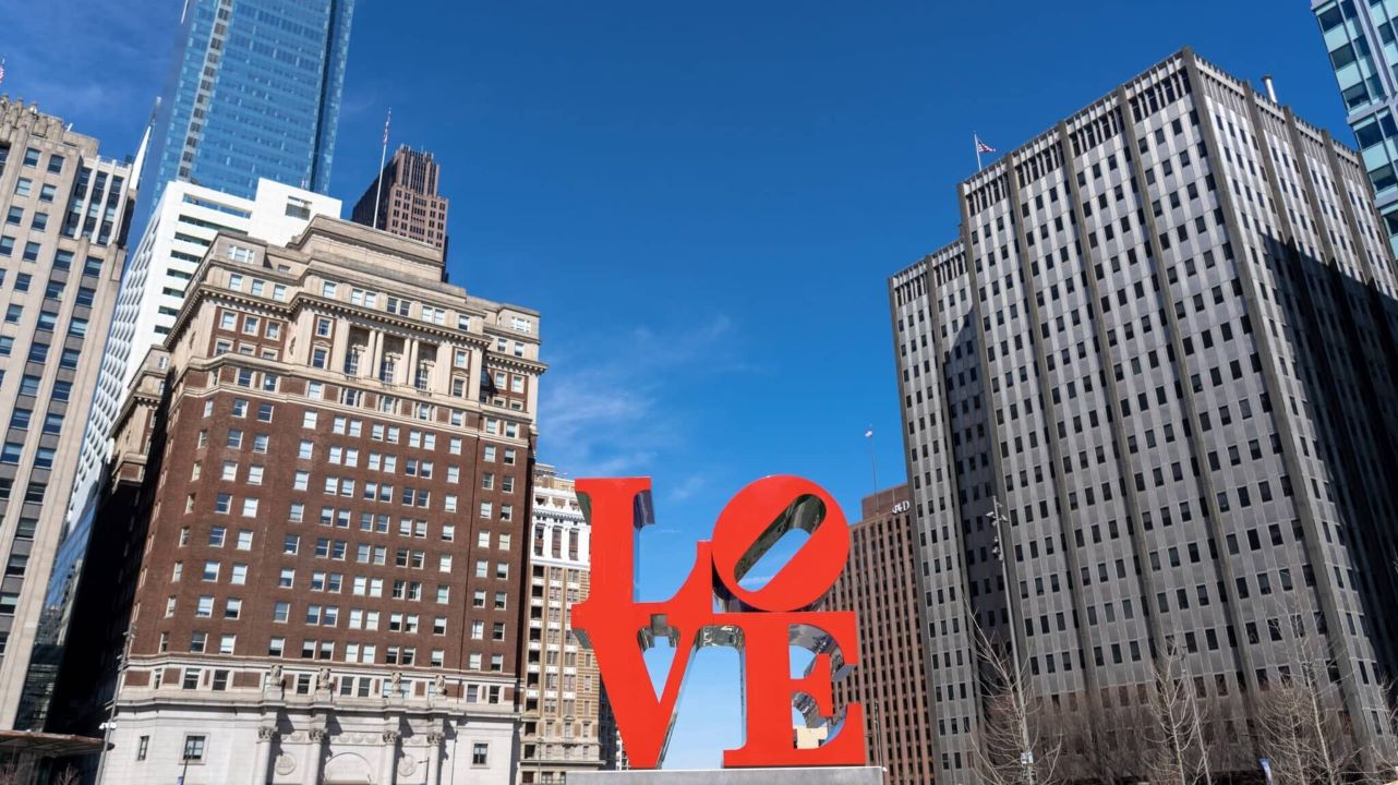 PHILADELPHIA, USA - MAR 2019 : Closeup Love park charactor over the modern building in Philadelphia on March 24, 2019. USA, Love Park, officially known as John F. Kennedy Plaza located in Center City